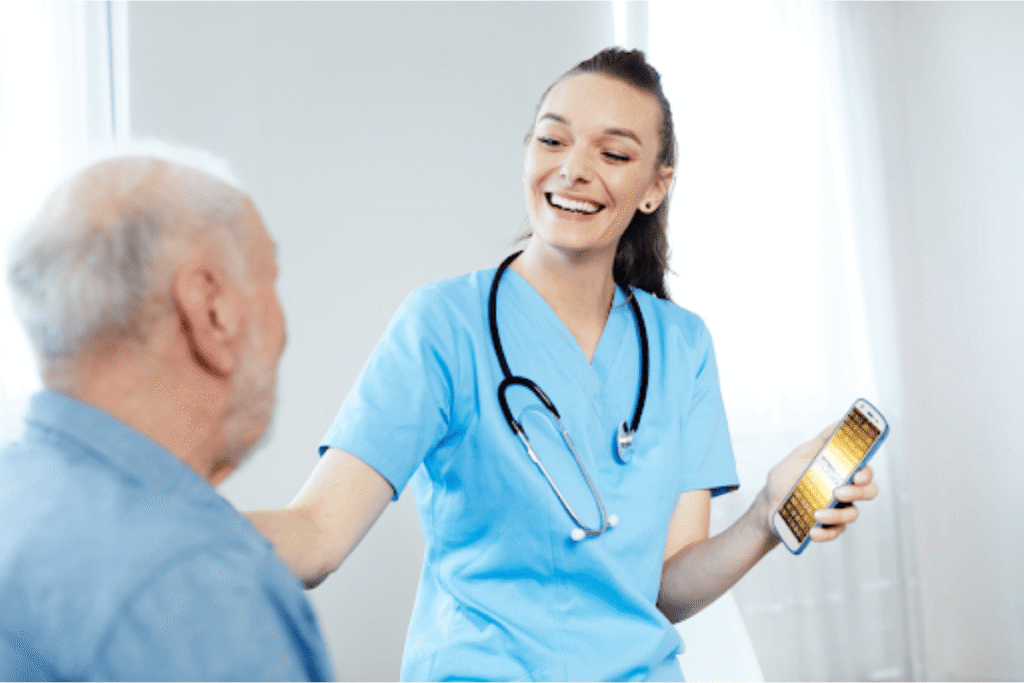 Woman nurse with Zebra device talking with older male patient.